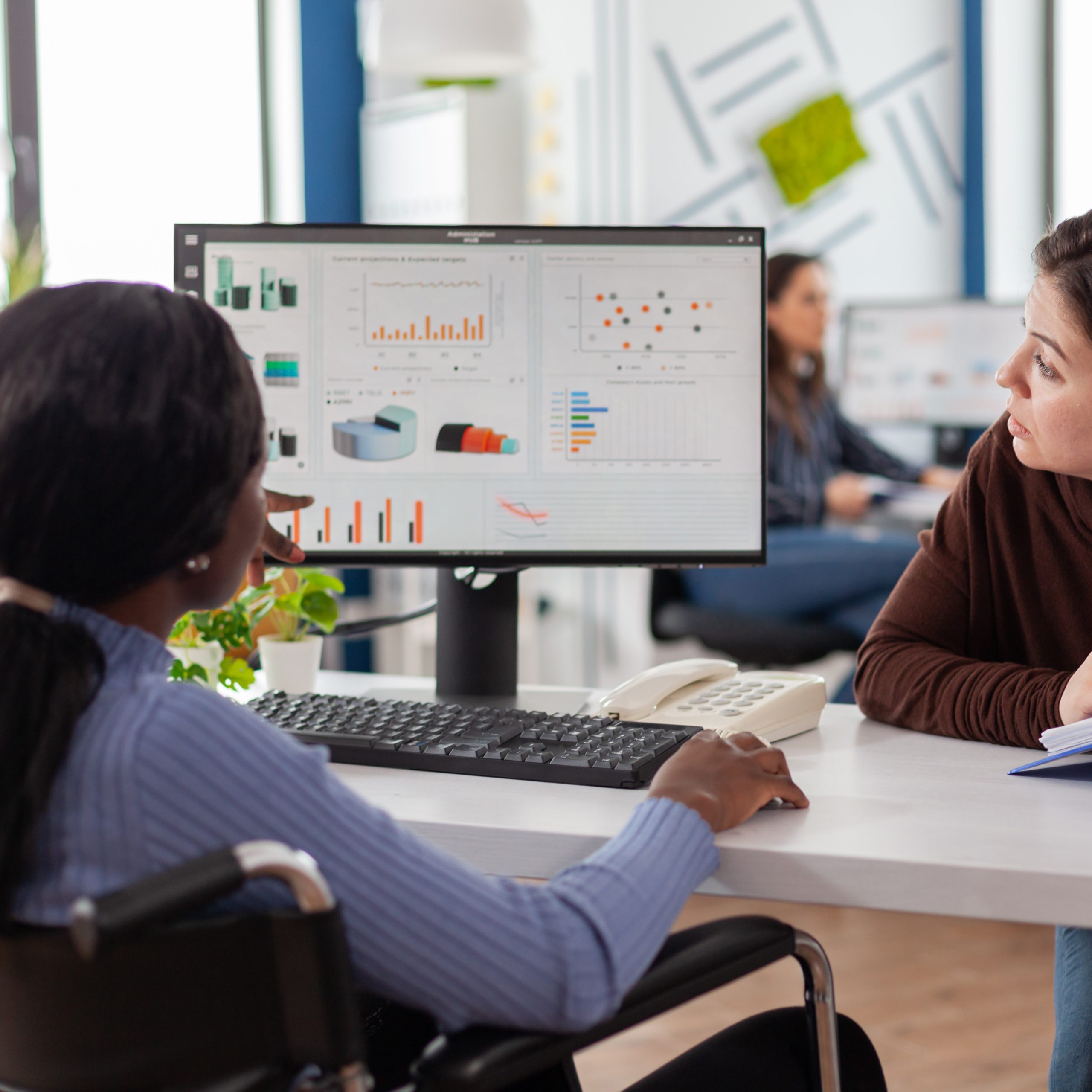 Manager discussing with invalid african woman company development plan